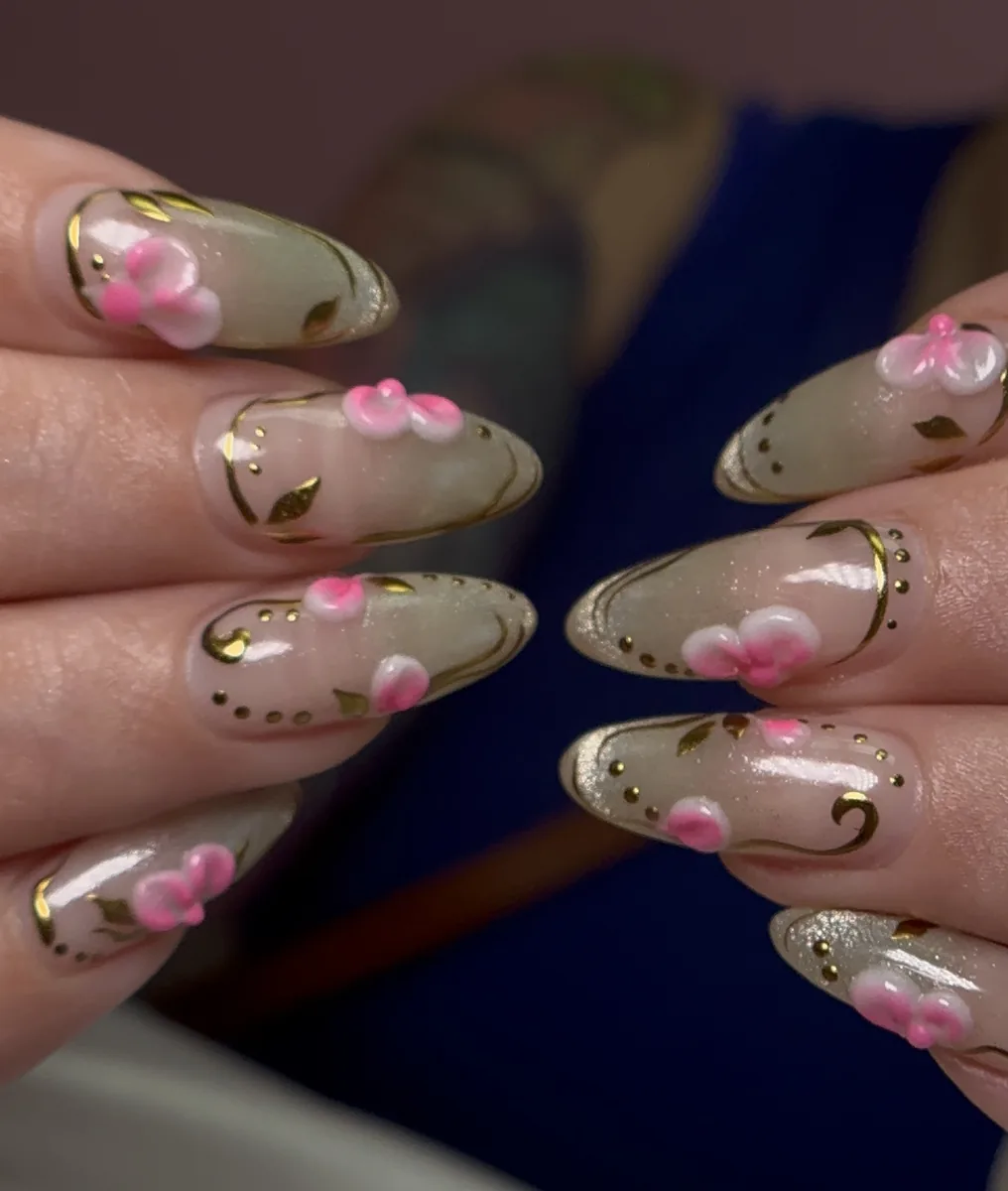 3D floral nail art with gold foil accents on almond-shaped pink nails at Polished by Kim