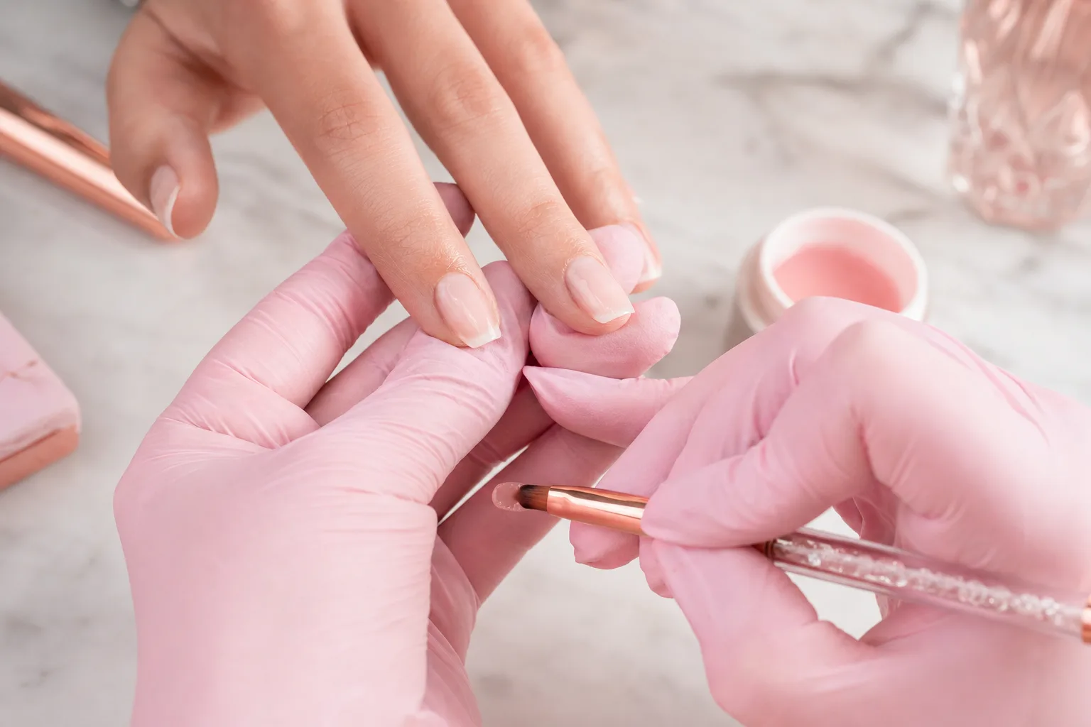 Nail technician applying builder gel to a natural nail for added strength at Polished by Kim