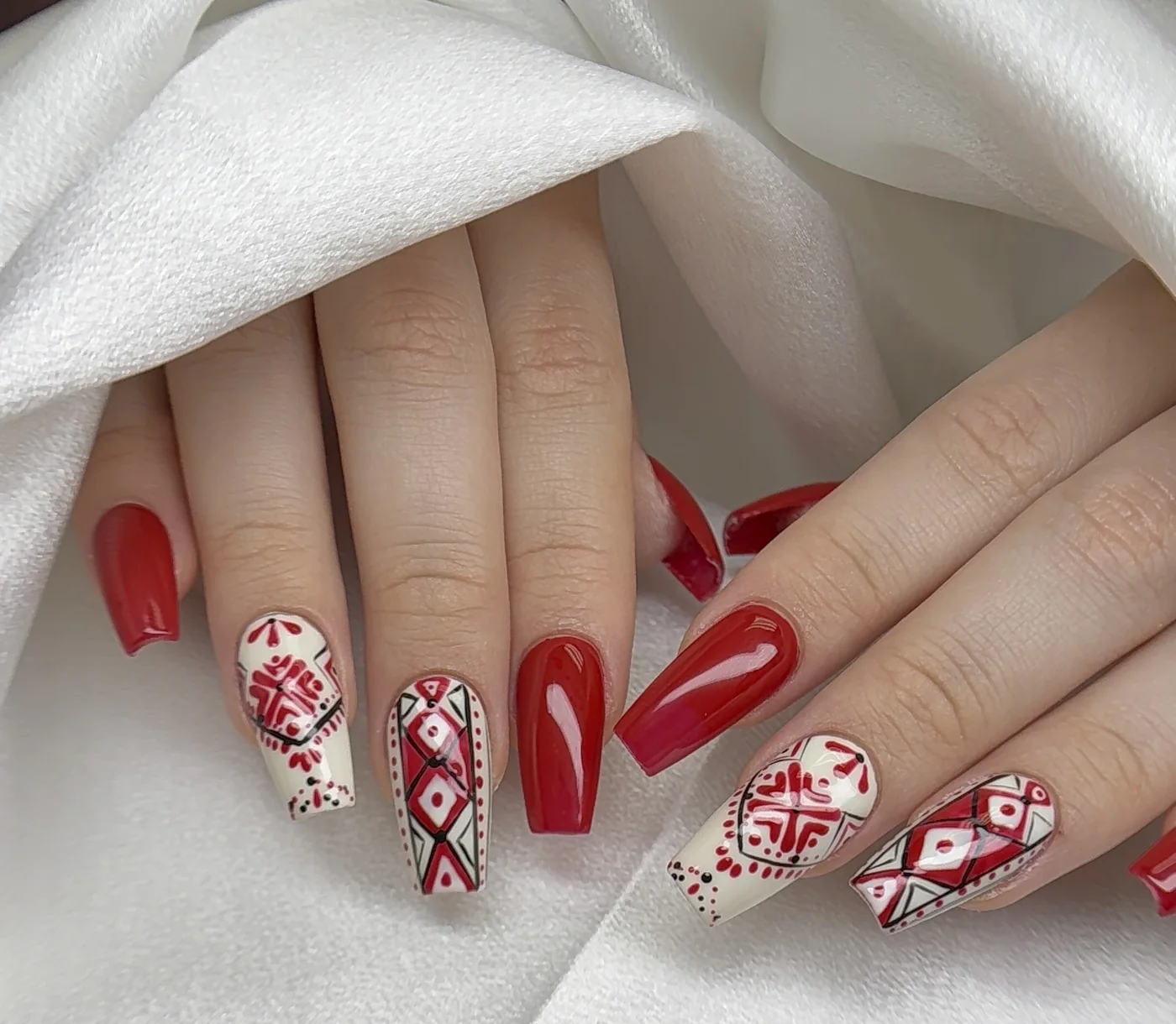 Red and cream Gel-X coffin nails with detailed folk-art patterns by Polished by Kim
