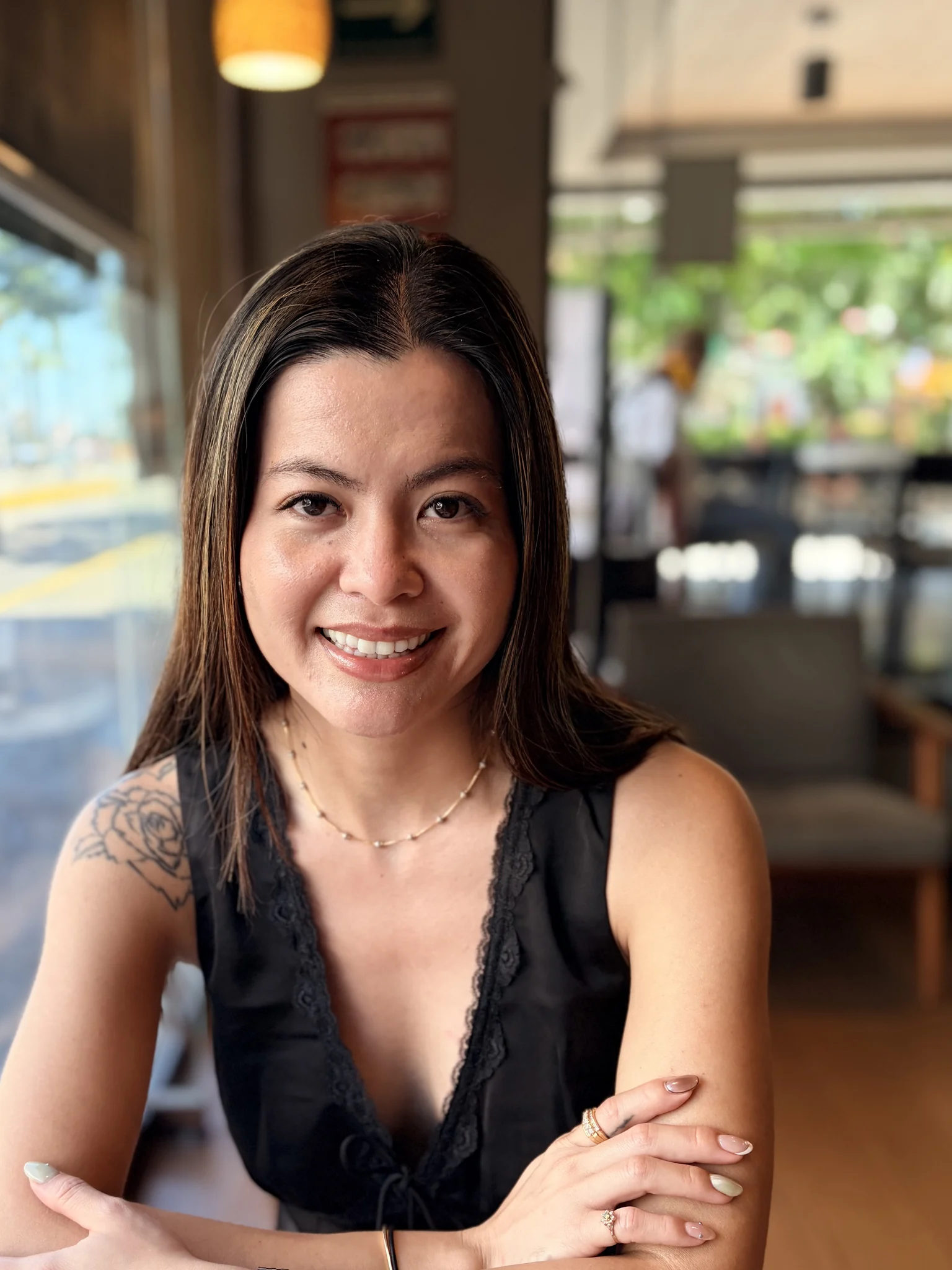 Kim, owner and nail artist at Polished by Kim, seated in a bright café