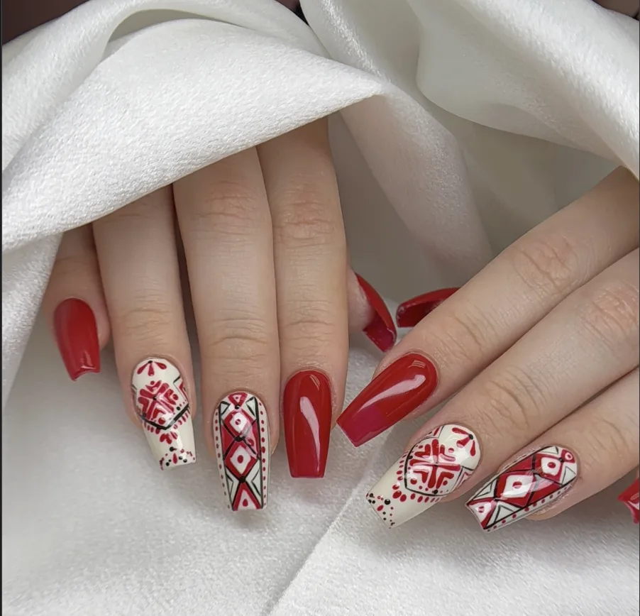 Long coffin nails with glossy red polish and folk-inspired nail art by Polished by Kim